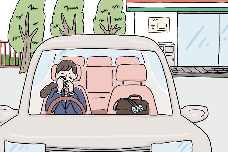 コンビニの駐車場にて、車の中で涙を流す女性