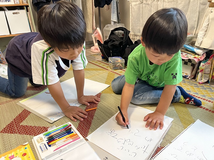 下坂さんの似顔絵を描く2人の孫