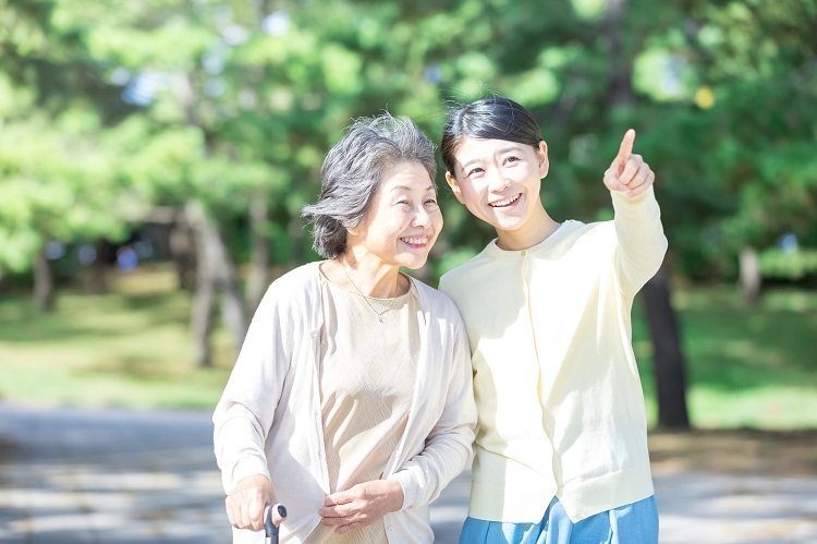 高齢者の女性に道案内をする女性